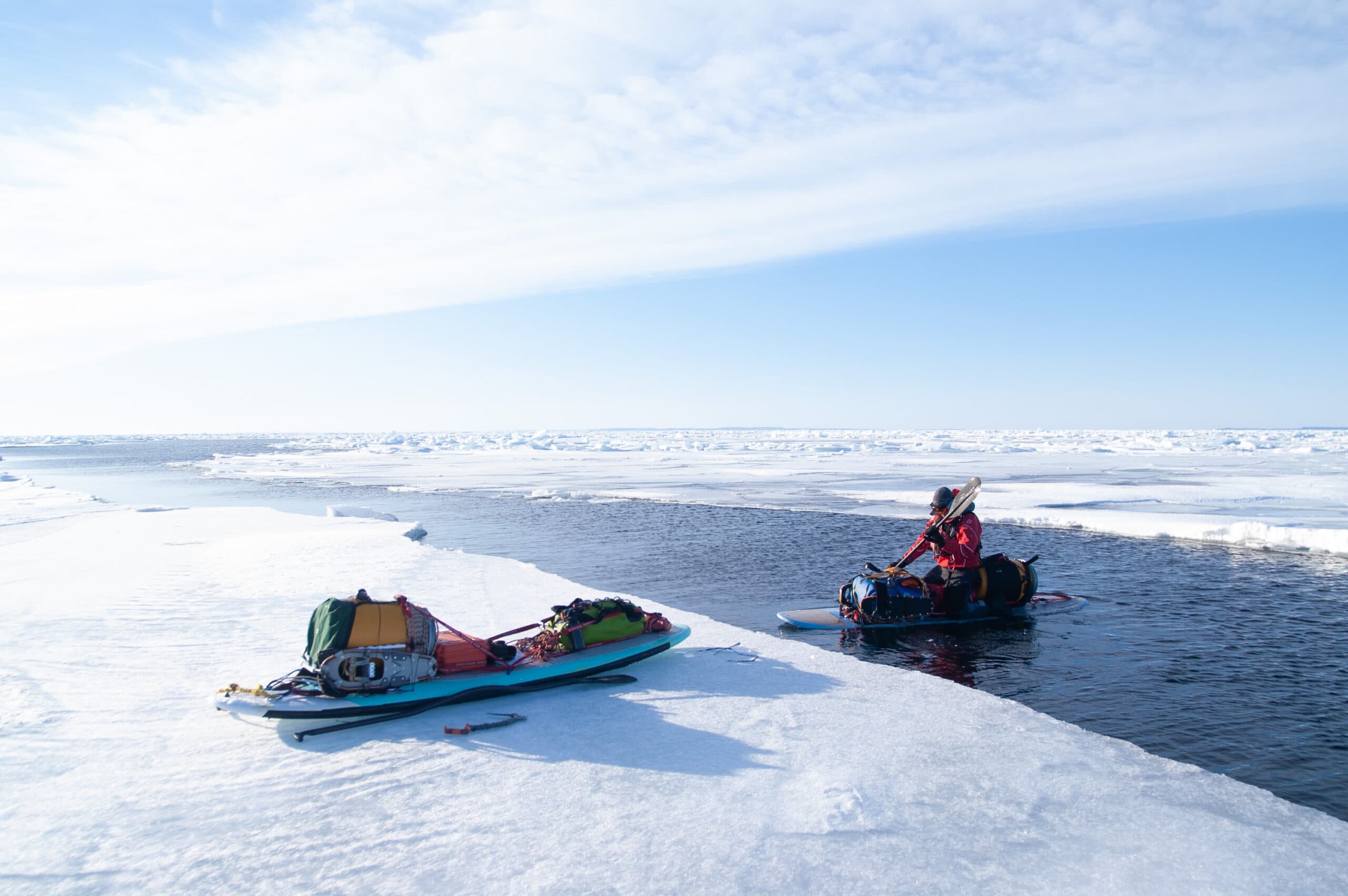 Davies paddles on a bleed of open water on the bay, surrounded by ice.